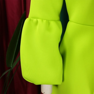 Detail of neon green puff sleeve with pleated cuffs on an elegant evening gown