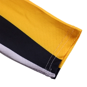 Close-up of honeycomb mesh fabric with yellow, black, and white contrast stitching