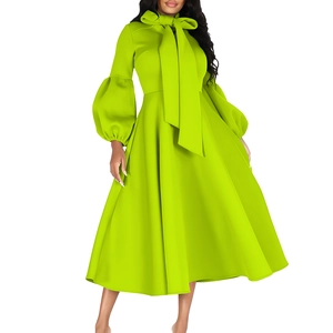 Detail view of the fluorescent green dress with bow tie neckline and puff sleeves