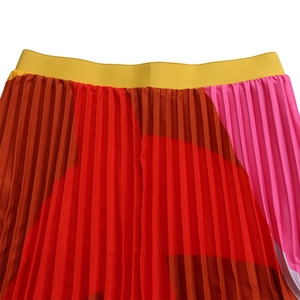Detail of pleated skirt featuring abstract geometric patterns and a yellow elastic waistband
