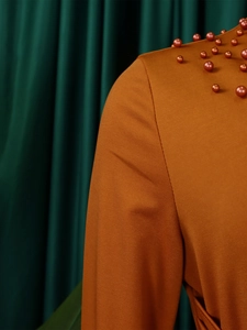 Macro shot of orange-brown gown collar with detailed beadwork and twill fabric texture