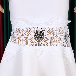 Detailed view of the intricate white lace embroidery and hollow-out waist design