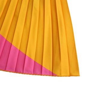 Detailed close-up of vibrant pink and yellow pleated fabric with professional hem stitching