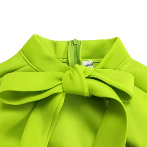 Detail of neon green high collar dress with large bow knot and invisible back zipper