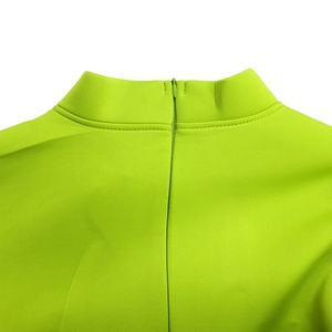 Detail of neon green stand collar with invisible zipper and premium fabric texture