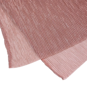 Close-up of rose gold pleated fabric with metallic luster and fine texture detail