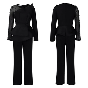 Detail of beaded mesh sleeves and asymmetric layered hem on elegant black jumpsuit