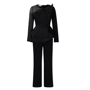 Detail of mesh sleeve with pearl beads and peplum waist on black evening jumpsuit