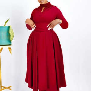 Close-up of elegant red dress featuring high neck pearl embellishments and cutout detail