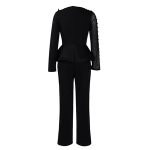 Detail of elegant black jumpsuit with sheer mesh sleeve and pearl embellishments on back
