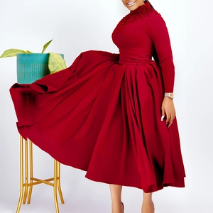 Detail of red high neck dress featuring intricate beaded embroidery on shoulders