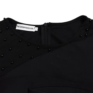 Detail of elegant black jumpsuit featuring mesh patchwork and beaded collar decorations