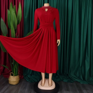 Detail of red high-neck dress showing elegant beaded embroidery and pleated waist design