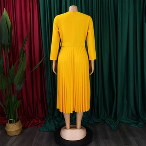 Detail view of the elegant pleated yellow dress with long sleeves and a discrete back zipper
