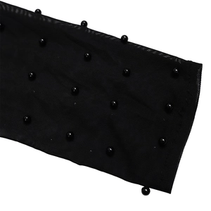 Close-up of black mesh fabric with decorative beadwork and intricate mesh texture