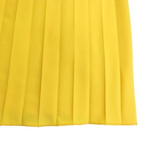 Close-up detail of bright yellow pleated fabric with professional overlock stitching finish