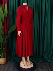 Detail of elegant red high-neck dress with intricate beadwork and waist pleats