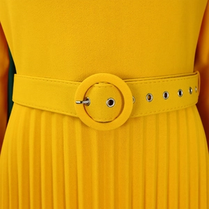 Detailed view of yellow pleated dress waist with a matching belt and metallic eyelets