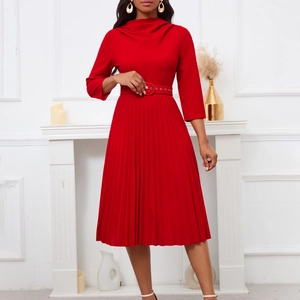 Detail of red pleated midi dress featuring a high neck and matching buckle belt