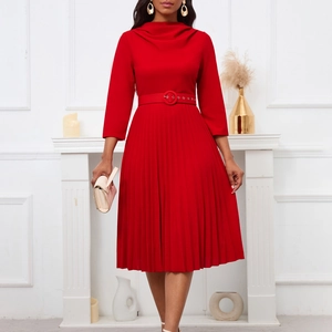 Close-up of elegant pleated red dress featuring a matching waist belt with a round buckle