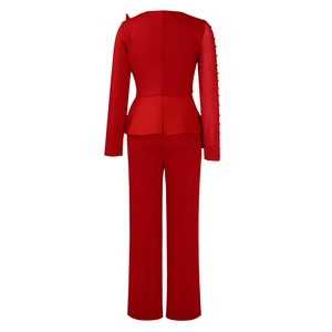 Detail of red jumpsuit showing mesh sleeve with pearls and peplum waist from the back