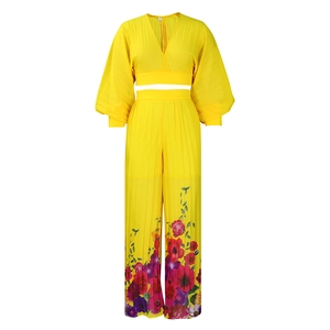 Detail of yellow pleated V-neck top and wide-leg trousers with floral print hem