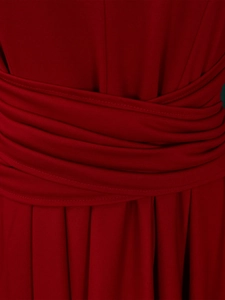 Detailed view of the red dress featuring a criss-cross pleated waist and accordion hem