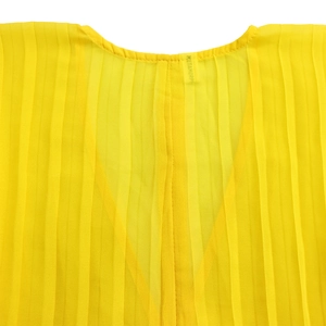 Close-up of vibrant yellow pleated chiffon fabric with round neckline and woven label