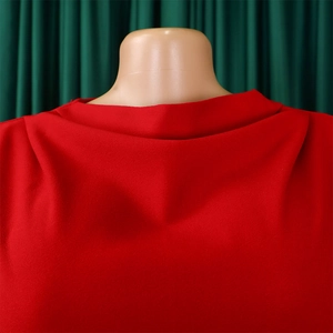 Detailed view of the red pleated turtleneck design and premium fabric texture