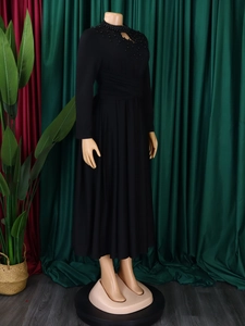 Detail of high neck black dress featuring exquisite beadwork and cutout design