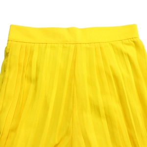 Detailed view of the fine vertical pleats and high-quality stitching on yellow wide-leg pants
