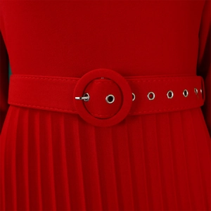 Detail of red pleated dress featuring a matching waist belt with a round buckle