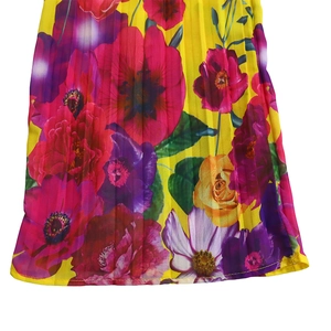 Detail of yellow pleated fabric featuring vibrant floral prints and precision hem stitching