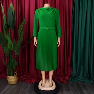 Detail of emerald green pleated dress featuring a draped neckline and matching belt
