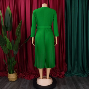 Detail view of the back of a green pleated long-sleeve dress with matching belt and zipper