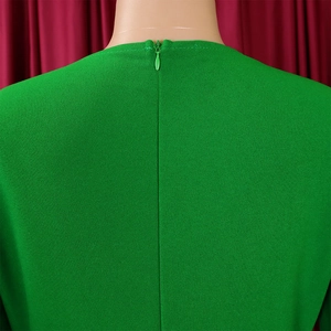 Detail view of the green pleated dress back with an invisible zipper and textured fabric