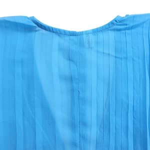 Detail of light blue chiffon top showing delicate pleated texture and round neckline