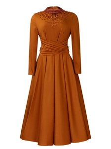 Detail of red bead necklace collar and pleated high waist on amber long sleeve gown