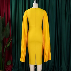 Detail of elegant yellow sheath dress showing pleated long sleeves and slim fit silhouette