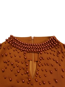 Detail of high neck dress with beaded pearls, cutout design, and invisible back zipper