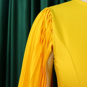 Close-up detail of pleated sleeves on a bright yellow evening party dress for women