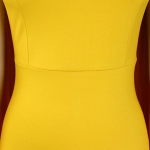 Detailed macro view of vibrant yellow pleated waist fabric with clean stitching craftsmanship