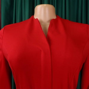 Détail d'une robe rouge à col en V avec patte de boutonnage cachée et plis sur un mannequin