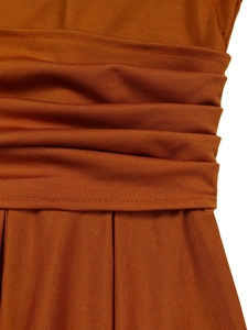 Detailed close-up of burnt orange pleated fabric showing ruched design and knit texture