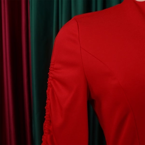 Détail de l'épaule avec design froncé vertical sur une robe plissée rouge élégante