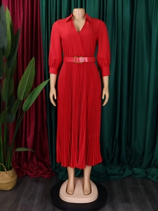 Detail of red maxi dress featuring pleated skirt and waist belt with golden buckle