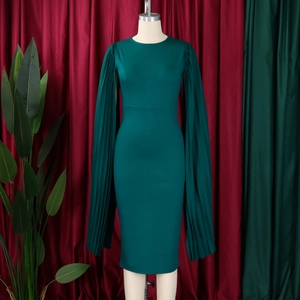 Detail view of dark green evening dress featuring pleated cape sleeves and a round neck