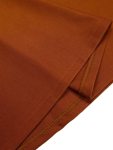 Detailed close-up of the caramel fabric stitching and inner overlock seam of the gown