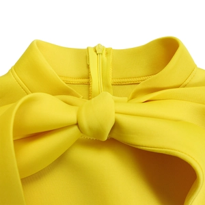 Detail of bright yellow puff sleeve dress featuring a stand collar and large bow decoration