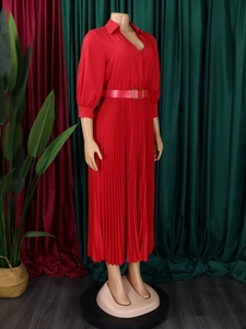 Detail view of red pleated dress featuring v-neck collar and waist belt with golden buckle